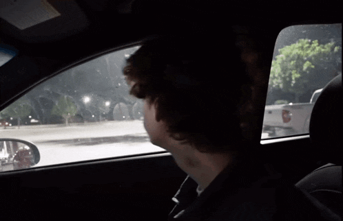 a man in a car with a sticker on the windshield that says ' airbag ' on it