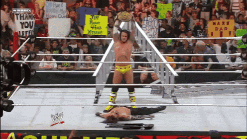 a man in a wrestling ring holds a sign that says jeff hudson 4 ever xtreme