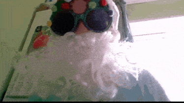 a person wearing a santa claus costume with a beard and sunglasses