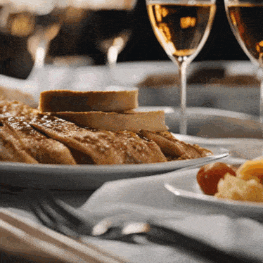 a plate of food sits on a table with wine glasses
