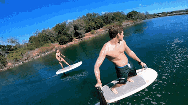 a man is sitting on a surfboard with the word pure on it