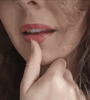 a close up of a woman 's face with red lipstick on her lips