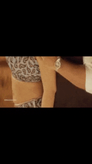 a close up of a woman 's stomach with a man 's arm around it .