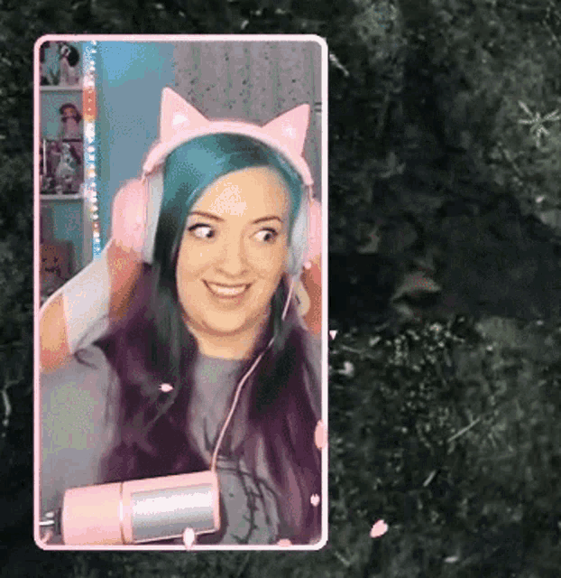 a woman with blue hair and pink headphones is smiling
