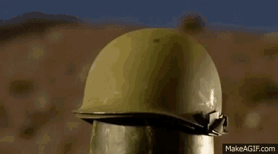 a soldier 's helmet is sitting on top of a watermelon in the desert .