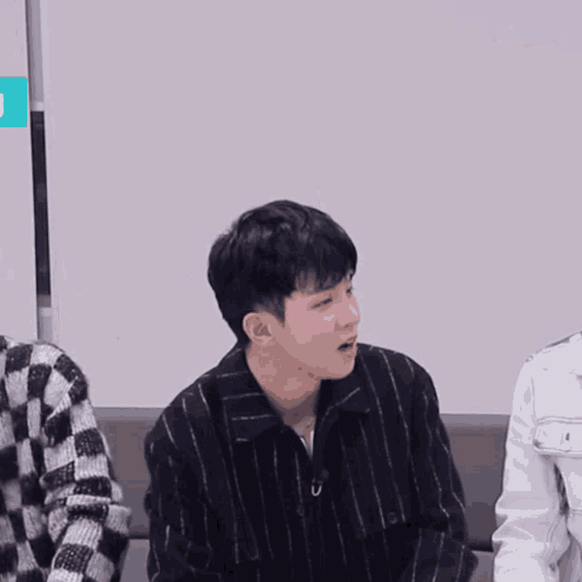 a young man in a striped shirt says oh in a foreign language