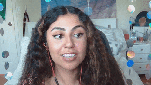 a woman wearing headphones looks at the camera