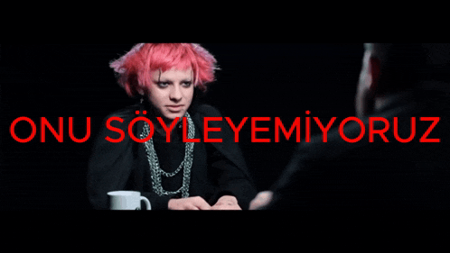 a woman with pink hair stands in front of a sign that says onu soyleyemiyoruz