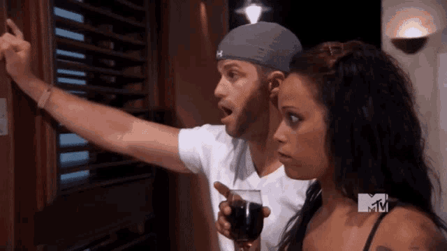 a man and a woman are watching a mtv program