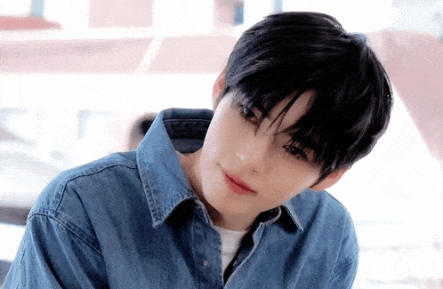a young man wearing a blue denim shirt and a white shirt