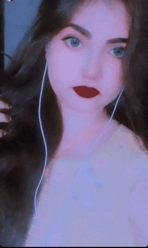 a woman wearing headphones and red lipstick is looking at the camera