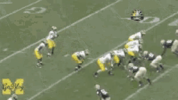 a blurred image of a football game with the word michigan on the bottom right