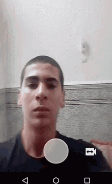 a young man is taking a picture of himself with a camera on his phone .