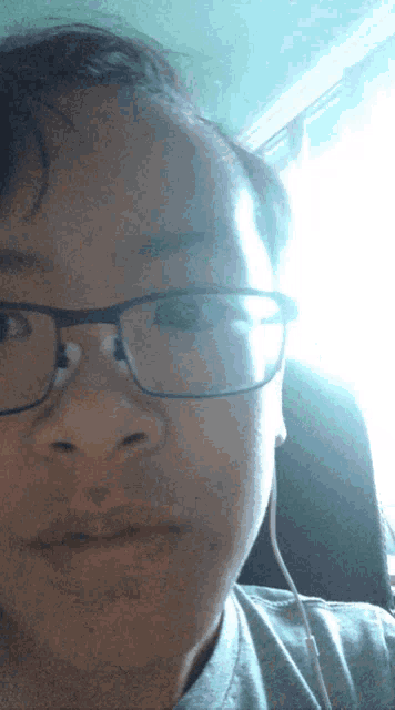 a close up of a person wearing glasses and headphones