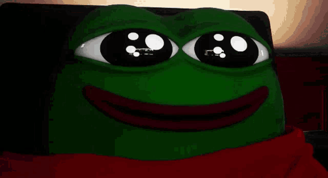 a green frog with a red scarf around his neck