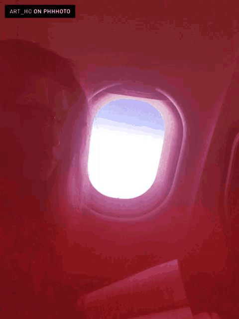 a picture of an airplane window with the caption art_ho on phhhoto
