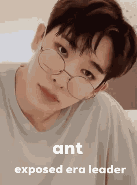 a young man wearing glasses is looking at the camera with a caption that says ant exposed era leader