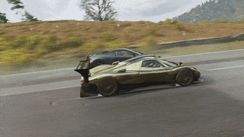 two sports cars are racing down a road and one has a large spoiler on the back