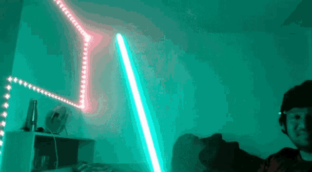 a person laying on a bed with a green lightsaber in front of them