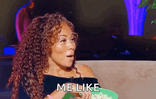 a woman with curly hair is holding a plate of food and saying `` me like '' .