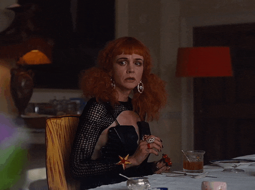 a woman with red hair sits at a table