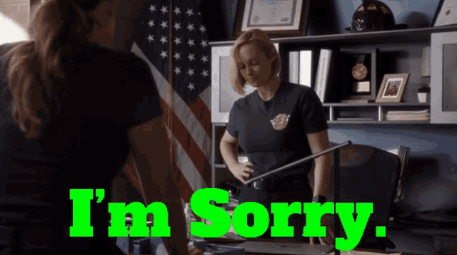 a woman standing in front of an american flag with the words " i 'm sorry " on the bottom