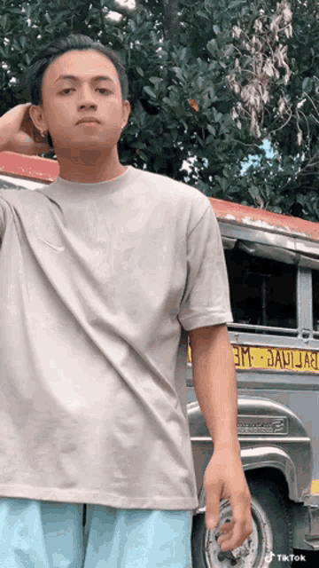 a man standing in front of a bus that has the word janija on it