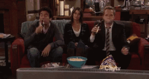 a group of people sitting on a couch watching a tv show