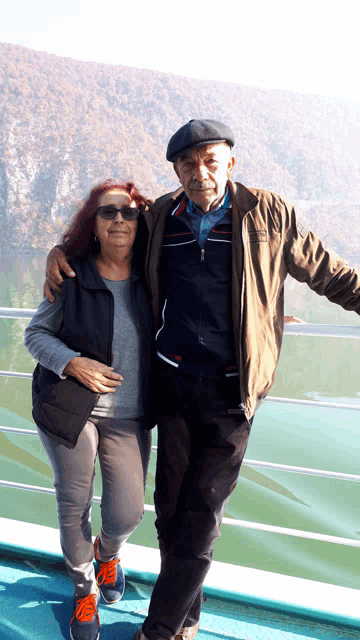 a man and woman posing for a picture with the man wearing a jacket that says tommy hilfiger