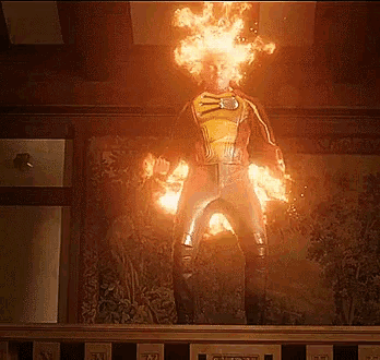 a man with flames coming out of his head stands on a balcony