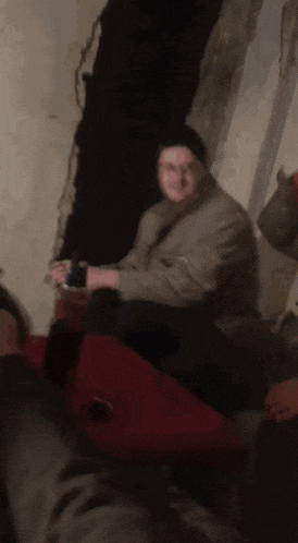 a blurry picture of a man sitting on a bed