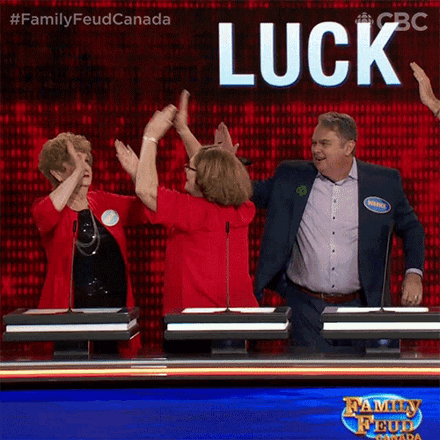 a group of people are giving each other a high five in front of a sign that says luck