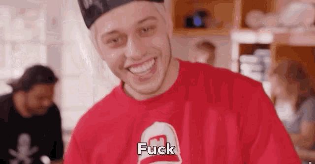 a man wearing a red shirt that says fuck