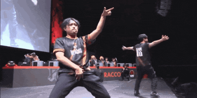 two men are dancing in front of a raccoon logo