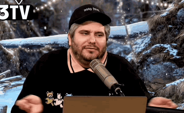 a man wearing a teddy bear hat is sitting in front of a laptop