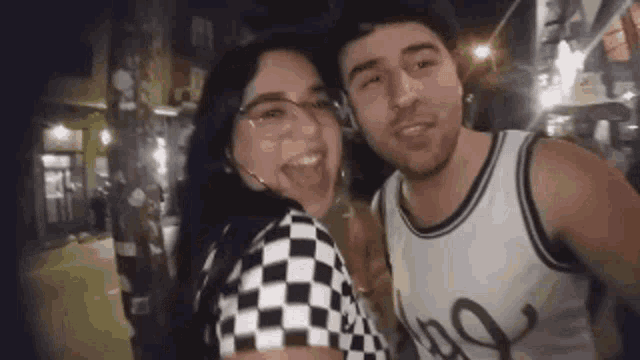 a man and a woman are standing next to each other on a street .
