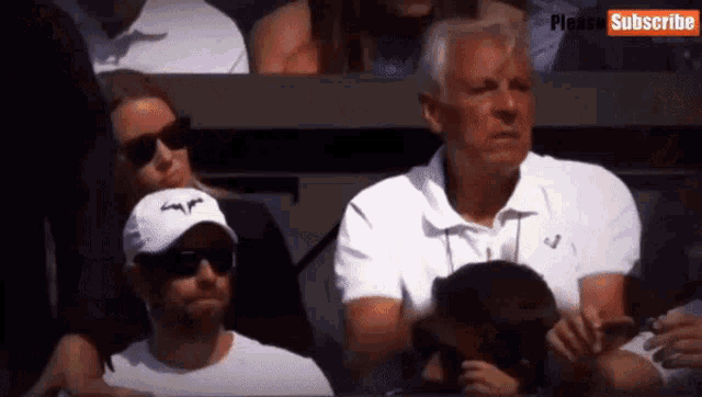 a man wearing a rafa hat sits in the audience