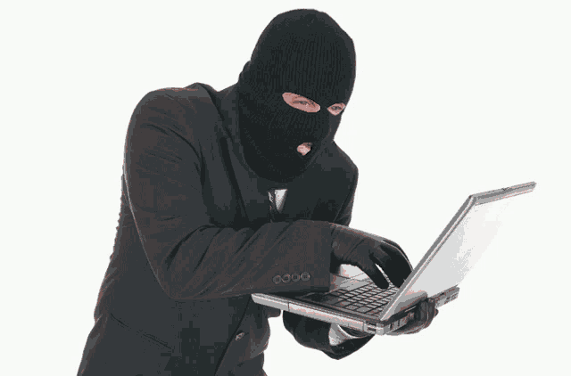 a man in a black suit and black gloves holds a laptop