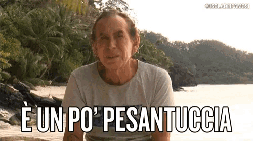 a man is sitting on a beach with the words e un po ' pesantuccia written on the bottom