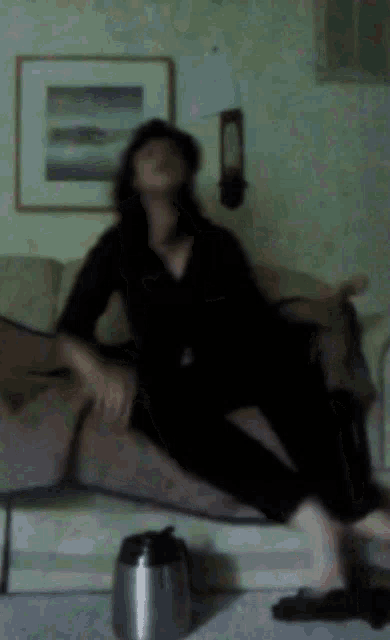 a woman is sitting on a couch with her eyes closed