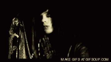 a black and white photo of a woman with her mouth open and a ghost behind her .