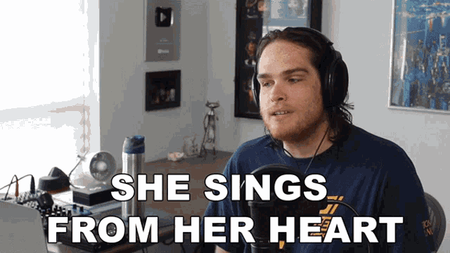 a man singing into a microphone with the words she sings from her heart