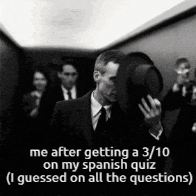 a man in a suit and tie is holding a hat over his face