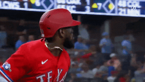 a baseball player wearing a red texas jersey and helmet