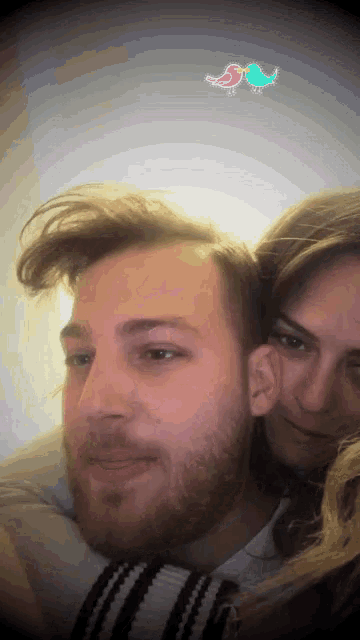 a man with a beard and a woman with a bird on their head