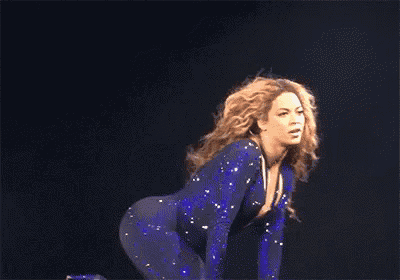 a woman is kneeling down with her hair blowing in the wind