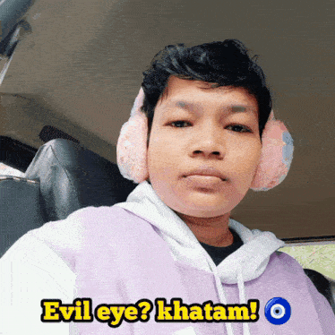 a man wearing ear muffs and a purple shirt with the words evil eye written on it