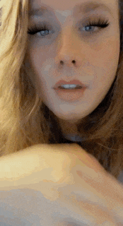 a close up of a woman 's face with long eyelashes and a smile on her face .