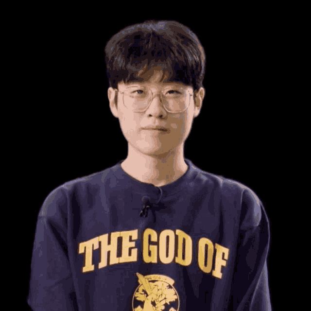 a young man wearing glasses and a blue shirt that says the god of on it