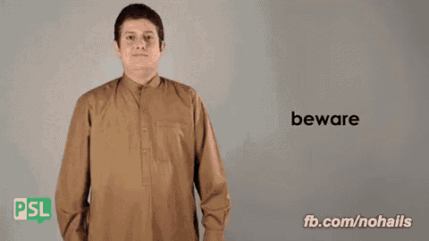 a man in a brown shirt says beware in a sign language